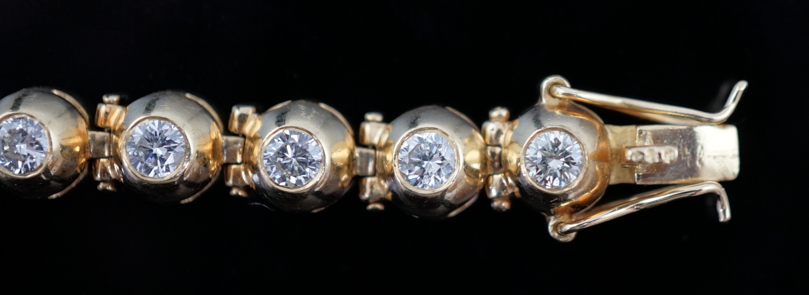 A modern 18ct gold and twenty six round brilliant cut diamond set line bracelet